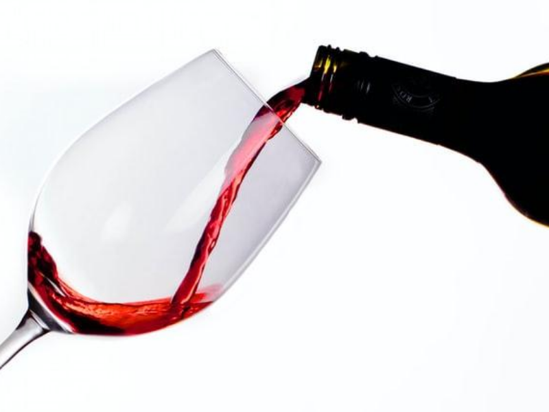 Nalewanie czerwonego wina do kieliszka