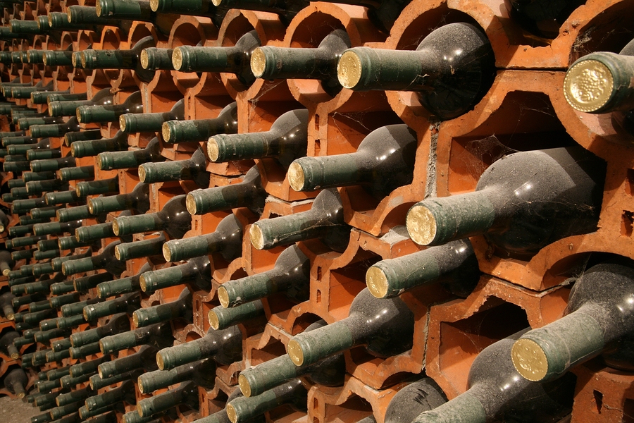 wina w piwniczce ulożone na ceglanych półkach