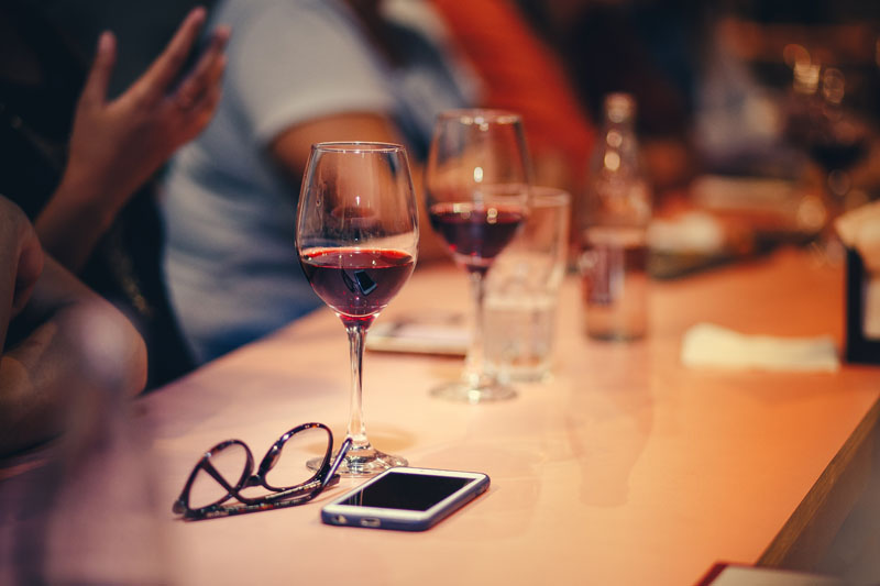 Czerwone wino w kieliszkach obok telefonu